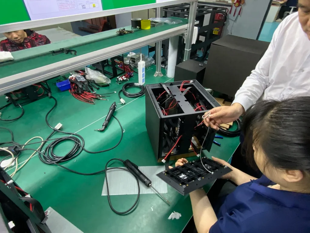 ledビジョンのキューブ型工場の製作工場内で説明受けている写真