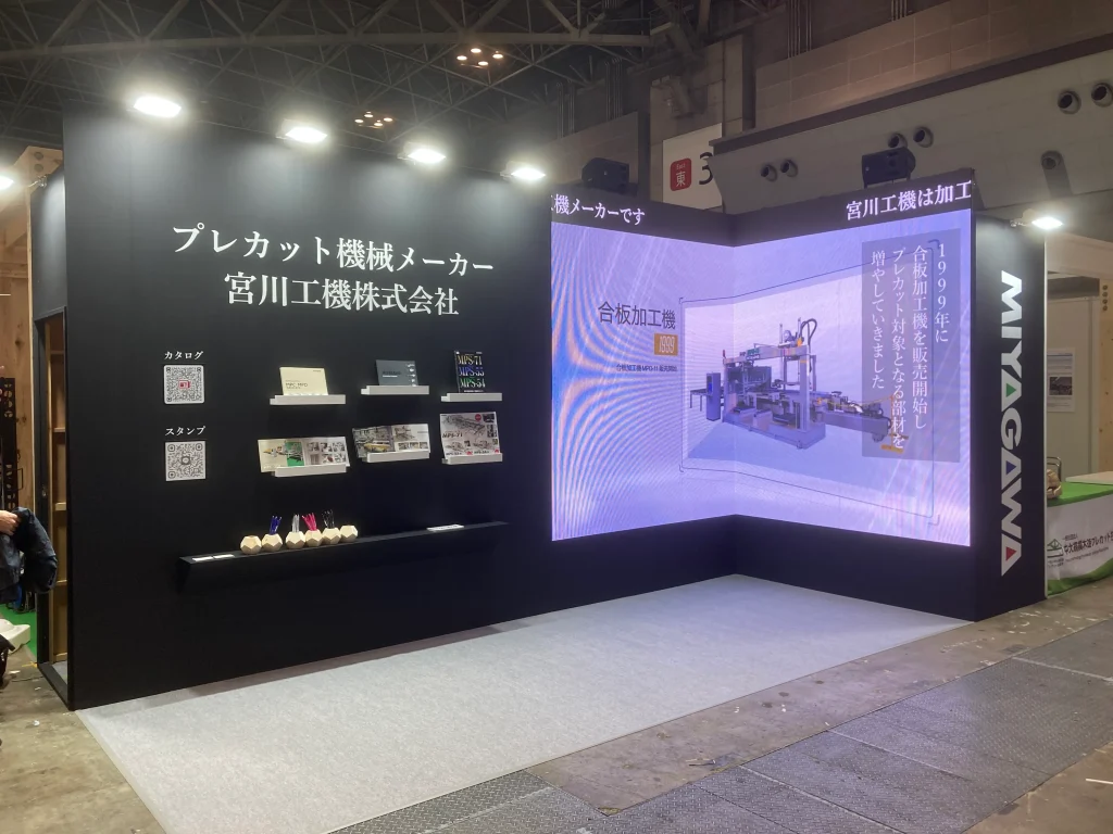 展示会でL型のサイネージ設置、自社の技術をアピールしている映像が流れている写真