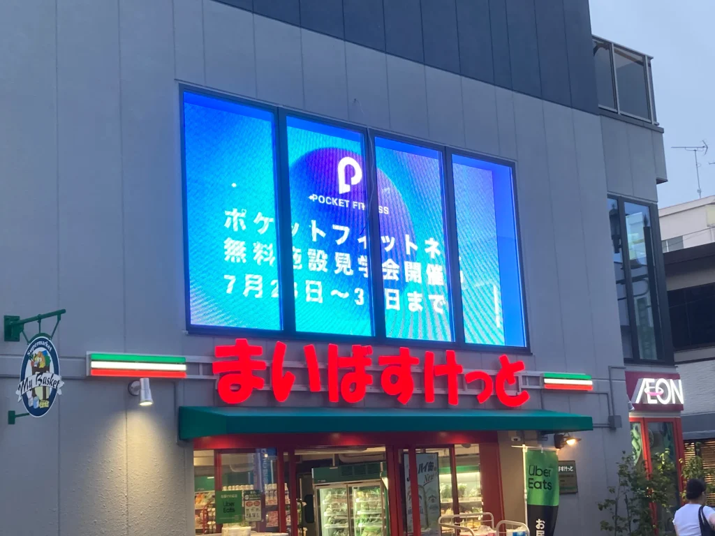 ビル2階の部屋の内側へ透過メッシュ式のLEDサイネージ取付た写真