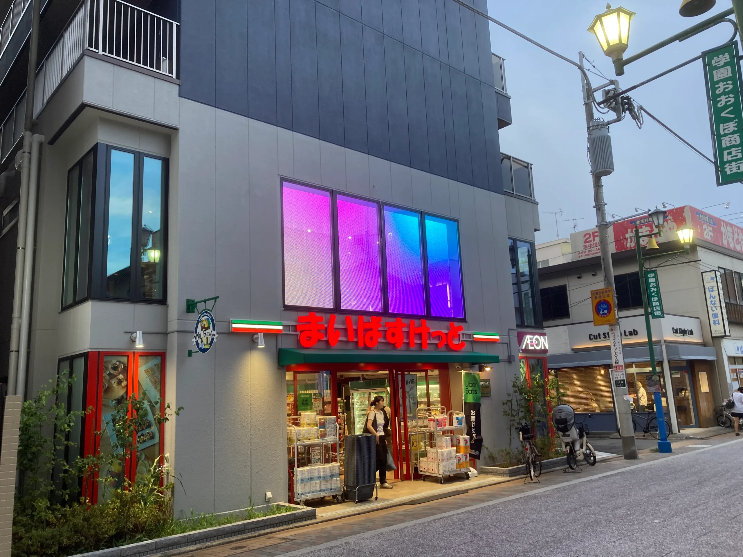 店舗の二階部屋側よりに透過タイプの LEDサイネージを取り付けた写真